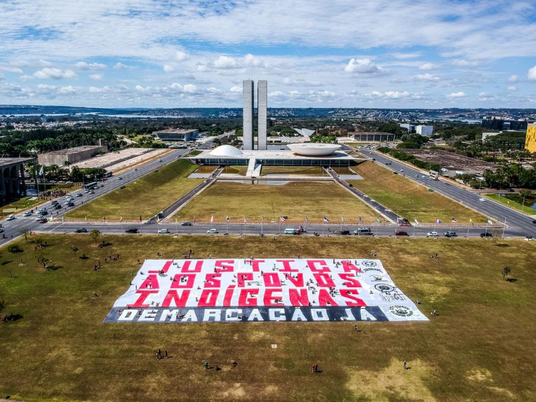 Indígenas estendem faixa na Esplanada dos Ministérios, em Brasília, no dia 15 de junho. Foto: Scarlett Rocha/Apib