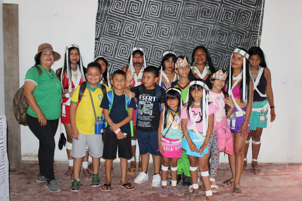 Professora Graciene Freire, da Escola Municipal Flores Infantil da Minha Vida e seus estudantes na inauguração do espaço AMAS do artesanato Marubo. Foto: AMAS